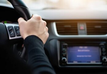 A close up on a man's hand on a steering wheel