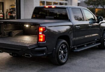 A black truck with a bed cover and its tailgate down